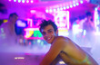 © Konstantin Bolotin - Night strip bar at resort. Naked skinny guy and bartender in foggy neon lights at party (blurred image)