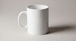 © A R - Clean white ceramic mug with handle casting a shadow on a light gray surface, studio product photography