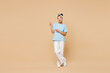 © ViDi Studio - Full body young woman of African American ethnicity wear blue t-shirt casual clothes doing winner gesture celebrate clenching fists say yes raise up leg isolated on plain pastel light beige background