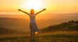 © Ulhan - Woman with arms outstretched embracing the sunrise from a hilltop