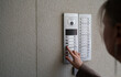 © M-Production - Woman rings the intercom from the street.