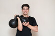 © Мар'ян Філь - Young man lifting two kettlebells for fitness, weight training and strength training at home exercise session. Young guy enjoys lifting weights, constantly training and smiling