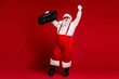 © deagreez - Santa with boombox celebrates the holiday season wearing red suit suspenders and hat in a bold festive studio setting
