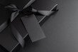 © thayra83 - Black Gift Box with Satin Ribbon and Blank Tag on Dark Background