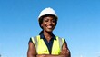 © Anna - Confident black female engineer smiling in a hard hat and safety vest. Professional construction worker portrait outdoors against a blue sky. Diversity and inclusion in the workforce with copy space