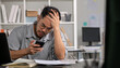 © amenic181 - Businessman looking stressed while using phone, Businessman working at office feels overworked and burnout