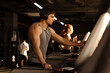 © Home-stock - Young muscular man selecting running program on treadmill in the gym, wearing headphones, ready for workout
