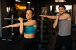 © Home-stock - Happy man and woman warming up and stretching arms before workout in fitness studio, both wearing sportwear and smiling
