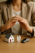 © thodonal - Concept of family protection with home and car insurance model