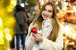 © JackF - Portrait of dreamily happy girl with Christmas balls in her hands at a street fair in the evening