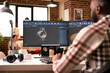 © DC Studio - Creative male developer using cad software in brick wall apartment, designing 3d models for construction. African american man seated at workstation creating industrial tool prototypes in home studio.