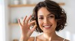 © SITI - Happy Woman Holds Golden Omega 3 Vitamin Capsule for Wellness and Beauty, Copy Space Left