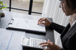 © Charlie's - Middle age Asian woman Auditor or internal revenue service staff senior business woman checking annual financial elderly woman pressing calculator..