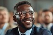 © nian - Portrait happy smiling African American ethnic male man guy businessman student in glasses formal suit listening business training class seminar presentation learning blurred crowd indoor meeting room