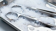 © 11 - Silver Surgical Instruments in Soapy Water on Metal Tray for Medical Cleaning