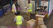 © vectorfusionart - Gathering warehouse team wearing safety vests checking schedule at staging, whiteboard and boxes