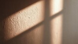 Warm sunlight through a window casts diagonal shadows on a rough plaster wall. Concept Warm sunlight, Window light, Diagonal shadows, Plaster wall texture, Natural lighting