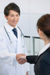 © UTS - 医師と握手するビジネスウーマン