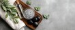 © B one - Spa-themed flat lay featuring a wooden board with bath salts, essential oil, stones, and fresh greenery