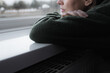 © Leart - Thoughtful sad woman sitting on a windowsill. Mental health and seasonal disorder. Winter scenery outside