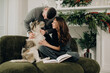 © dsheremeta - Couple cuddling dog relaxing during christmas holiday