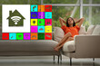 © New Africa - Smart home. Different icons on virtual screen against relaxed woman in room
