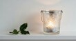 © Igor - Decorative candle holder with lit candle and greenery on shelf