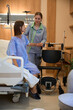 © Svitlana - Female patient being helped by nurse from bed to wheelchair