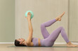 © zhagunov_a - Woman doing pilates exercise with fitness ball indoors