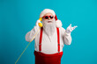 © deagreez - Santa on the retro cable telephone and red suspenders smiles blue backdrop perfect for Christmas promotions and festive holiday campaigns