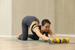© zhagunov_a - Woman doing fitness exercise with dumbbells on mat