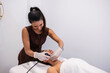 © PintoArt - Beautician performing professional radiofrequency facial treatment on woman