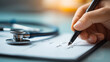© kaliel - Hand writing beside a stethoscope, symbolizing diagnosis planning, accurate records, and coordinated healthcare decisions.