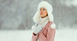 © rohappy - Young woman outdoors, girl in winter hat, sweater on snowy forest background with snowflakes