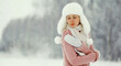© rohappy - Young woman outdoors, girl in winter hat, sweater on snowy forest background with snowflakes