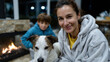© Milos - A heartfelt scene captures a mother and son cuddling with their loyal dog by the fireplace, embodying warmth, love, and the joy of family moments on a cozy night.