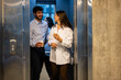 © Zoran Jesic - Business colleagues exiting elevator enjoying coffee break