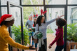 © Wavebreak Media - Diverse friends wearing antlers and Santa hat greeting at modern house front entrance with gifts