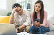 © KMPZZZ - Stressed financial owe asian young couple love sitting suffer, stressed and confused by calculate expense from credit card bill, no money to pay, mortgage or loan. Debt, bankrupt or bankruptcy people.