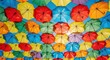 © riponhossain - Brightly colored umbrellas hanging overhead against a clear blue sky.