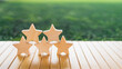 © sommart - Stacked five wooden stars on table with green background symbolizing high rating, excellent review, top quality, trust, performance ranking, brand credibility, and customer satisfaction.