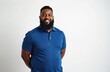 © Pete - Smiling, bearded man of color in 30s wears blue polo shirt. Stands against plain white background, arms clasped behind back. Friendly, approachable portrait suggests trustworthiness, professionalism.