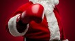© HasnaAkther - Santa claus wearing boxing gloves ready to fight with red background
