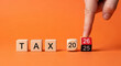 © AucArtStudio - 2026 business year end christmas new year planning and tax transition concept with wooden blocks and hand changing date for holiday accounting