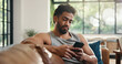 © Wess/peopleimages.com - Relax, reading and man with phone on couch, check social media or browsing internet for digital book. Email notification, texting or person chilling in home with mobile app, blog post or watch video