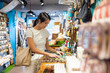 © leungchopan - Woman shopping for souvenirs at local gift shop