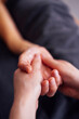 © Dasha Petrenko - Close-up of two hands gently holding each other, showcasing connection and intimacy, with soft textures and warm lighting creating a serene atmosphere of trust and support