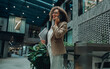© Yaroslav Astakhov - diverse female professional on phone with files while walking through atrium, multitasking with laptop