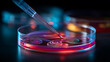 © Jhati - Close up of pipette dropping liquid into a petri dish with colorful liquid inside it