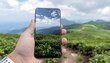 © Angelina - Capturing breathtaking mountain vistas and lush green tea fields on a smartphone, showcasing the beauty of nature's landscapes and modern technology